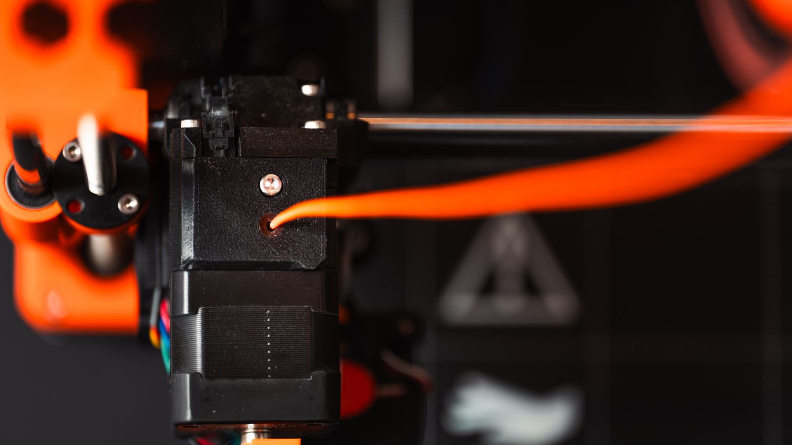Close-up of an FDM 3D printer extruder laying down filament