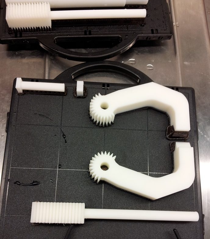 3D-printed robotic gripper parts on a calibration plate